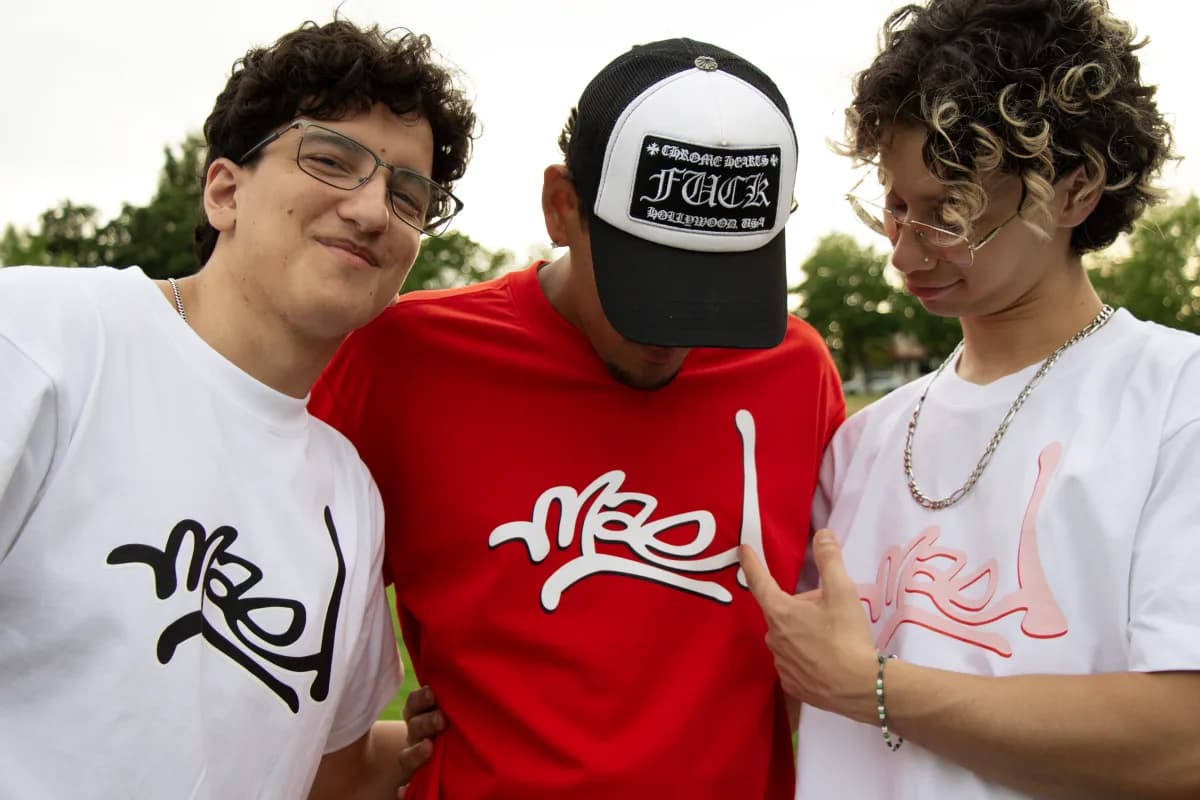Three people wearing Mael tees with the logo tag