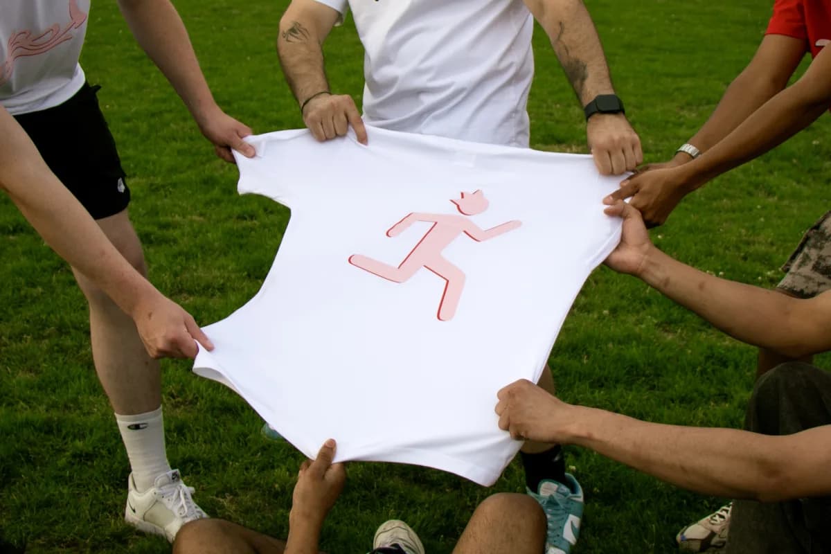 Group holding a white Mael tee with the runner icon