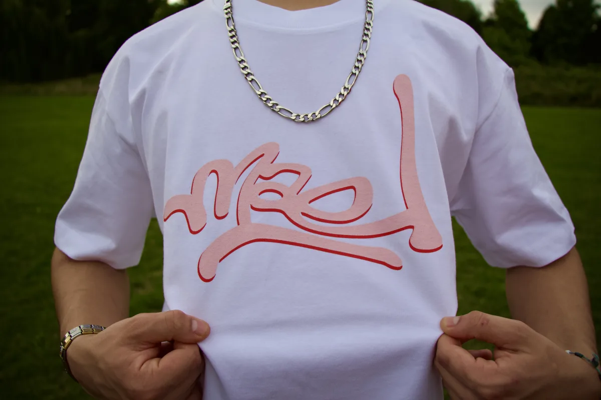 Close-up of the Mael logo tag on a white tee